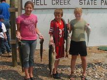 Charlie South, Ross Ryan and Sammi South with the fish they caught in the Hell Creek Kid's fishing tournament.  Ross's walleye was 30